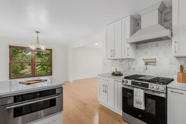 a kitchen with stainless steel appliances white cabinets and a stove
