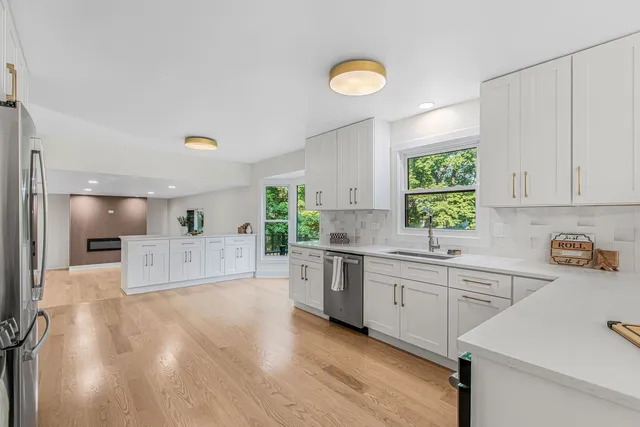a large kitchen with a lot of counter space and wooden floor