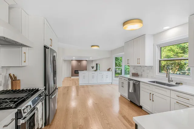 a large kitchen with cabinets wooden floor and stainless steel appliances