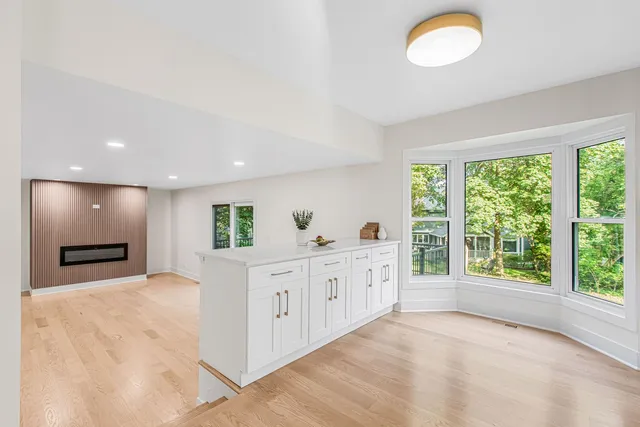 a large white kitchen with granite countertop a sink and white cabinets