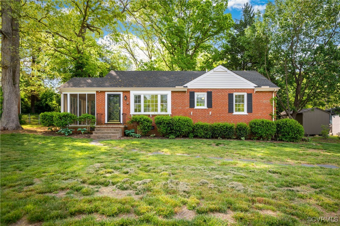 a front view of a house with a yard and trees