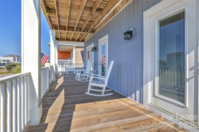 a view of a porch with wooden floor and outdoor seating