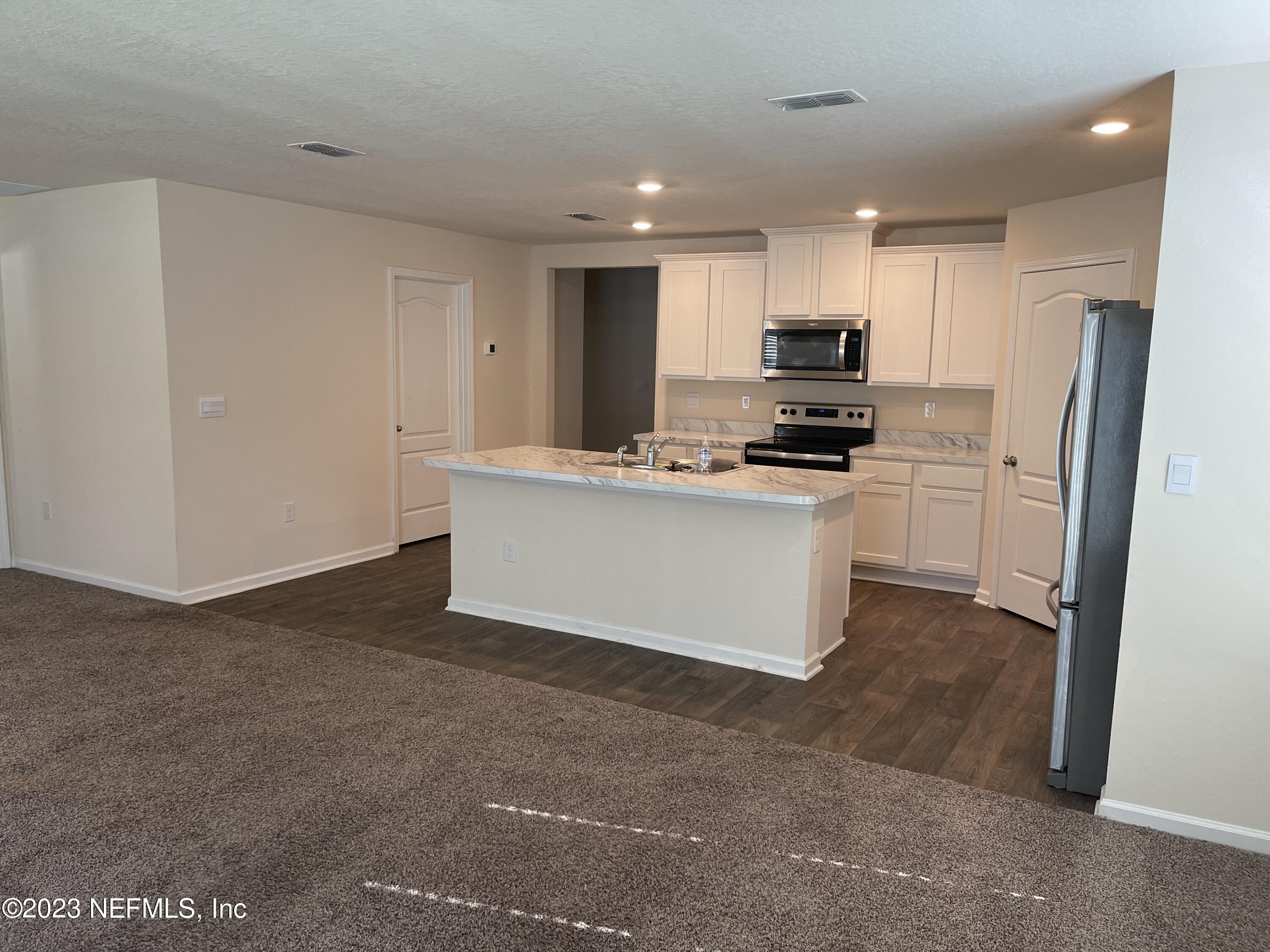 581 Morgans Treasure Road St. Augustine, FL 32084 - Photo 3 of 20 a kitchen with kitchen island a sink stove and refrigerator