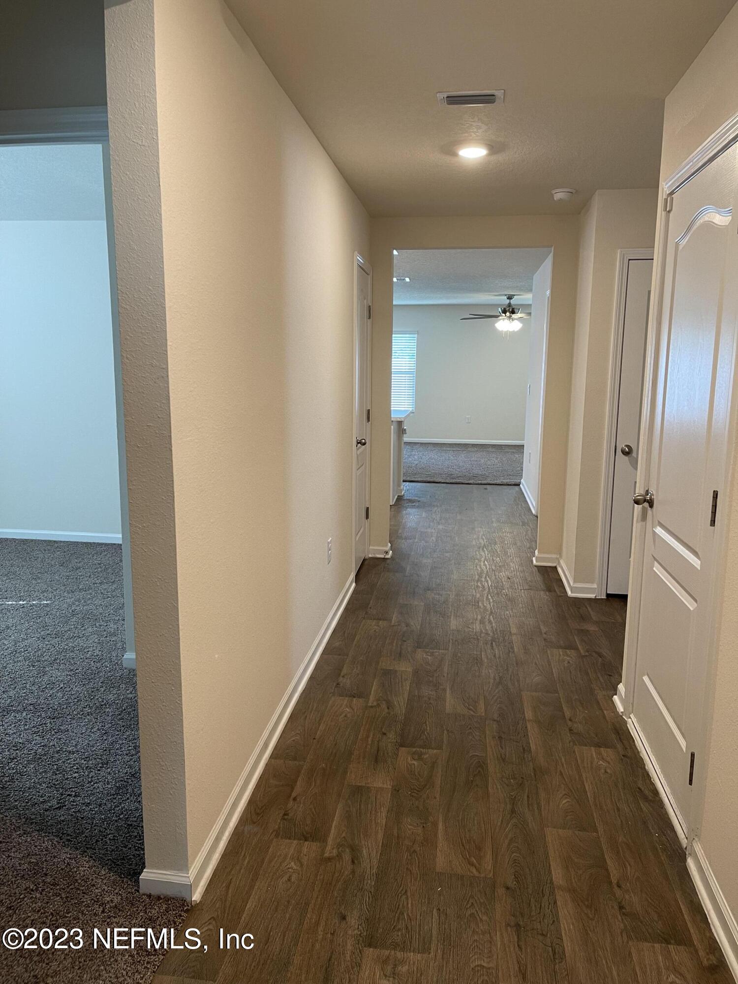 581 Morgans Treasure Road St. Augustine, FL 32084 - Photo 10 of 20 a view of a hallway with wooden floor