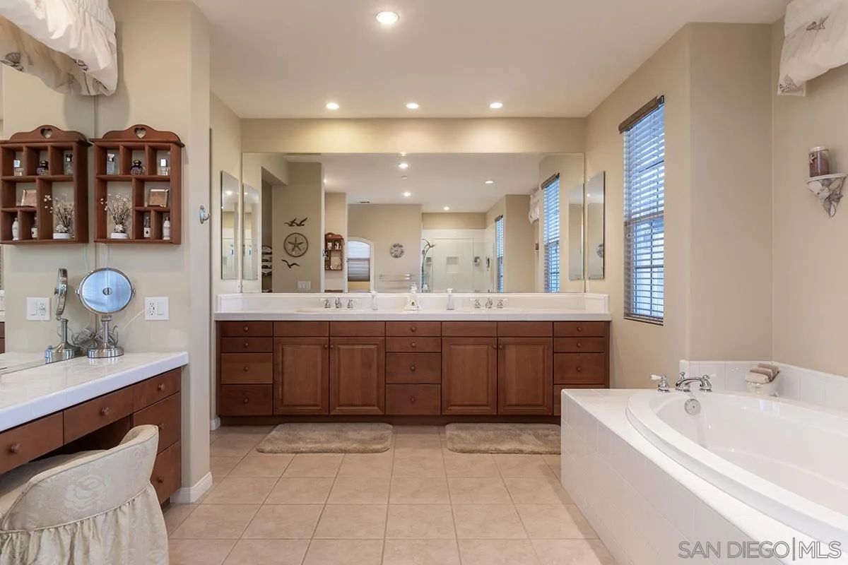16333 Deer Ridge Road San Diego, CA 92127 - Photo 23 of 43 a bathroom with a double vanity sink a mirror and a bathtub
