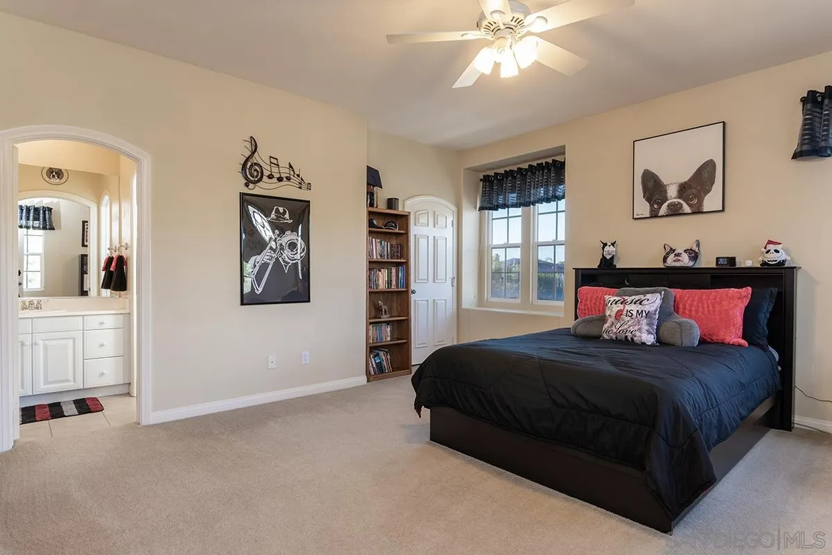 16333 Deer Ridge Road San Diego, CA 92127 - Photo 28 of 43 a bedroom with a bed and a chandelier