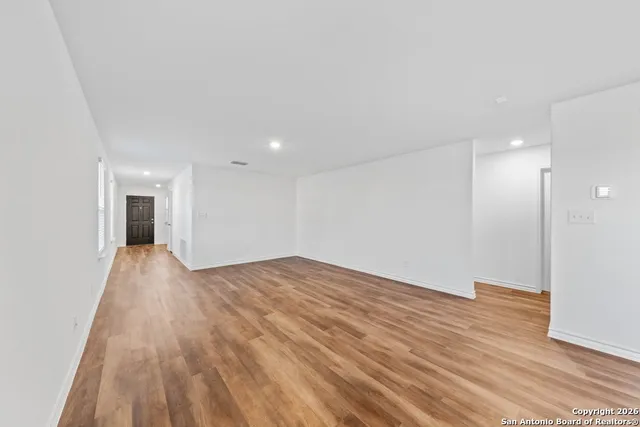 a view of empty room with wooden floor