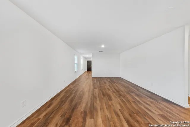 a view of empty room with wooden floor