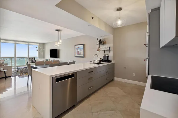 a kitchen with kitchen island granite countertop a sink appliances and cabinets