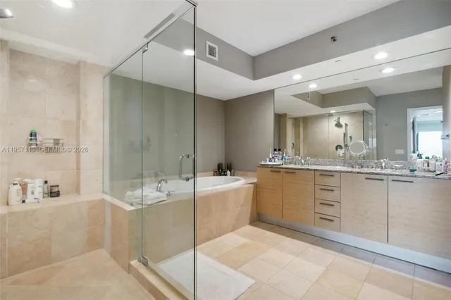 a spacious bathroom with a double vanity sink a mirror and a shower