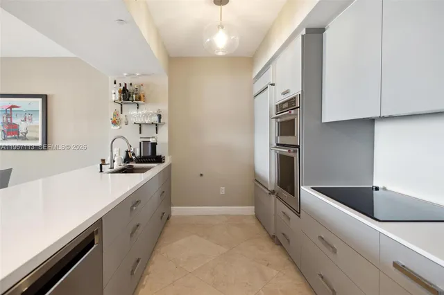 a large kitchen with stainless steel appliances a sink and a refrigerator