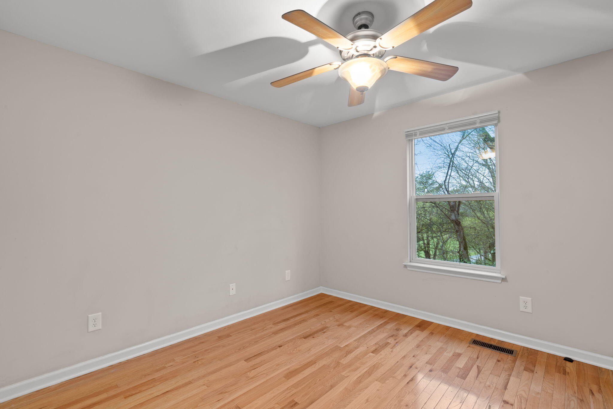 439 Town Creek Road Benton, TN 37307 - Photo 24 of 30 an empty room with wooden floor chandelier fan and windows