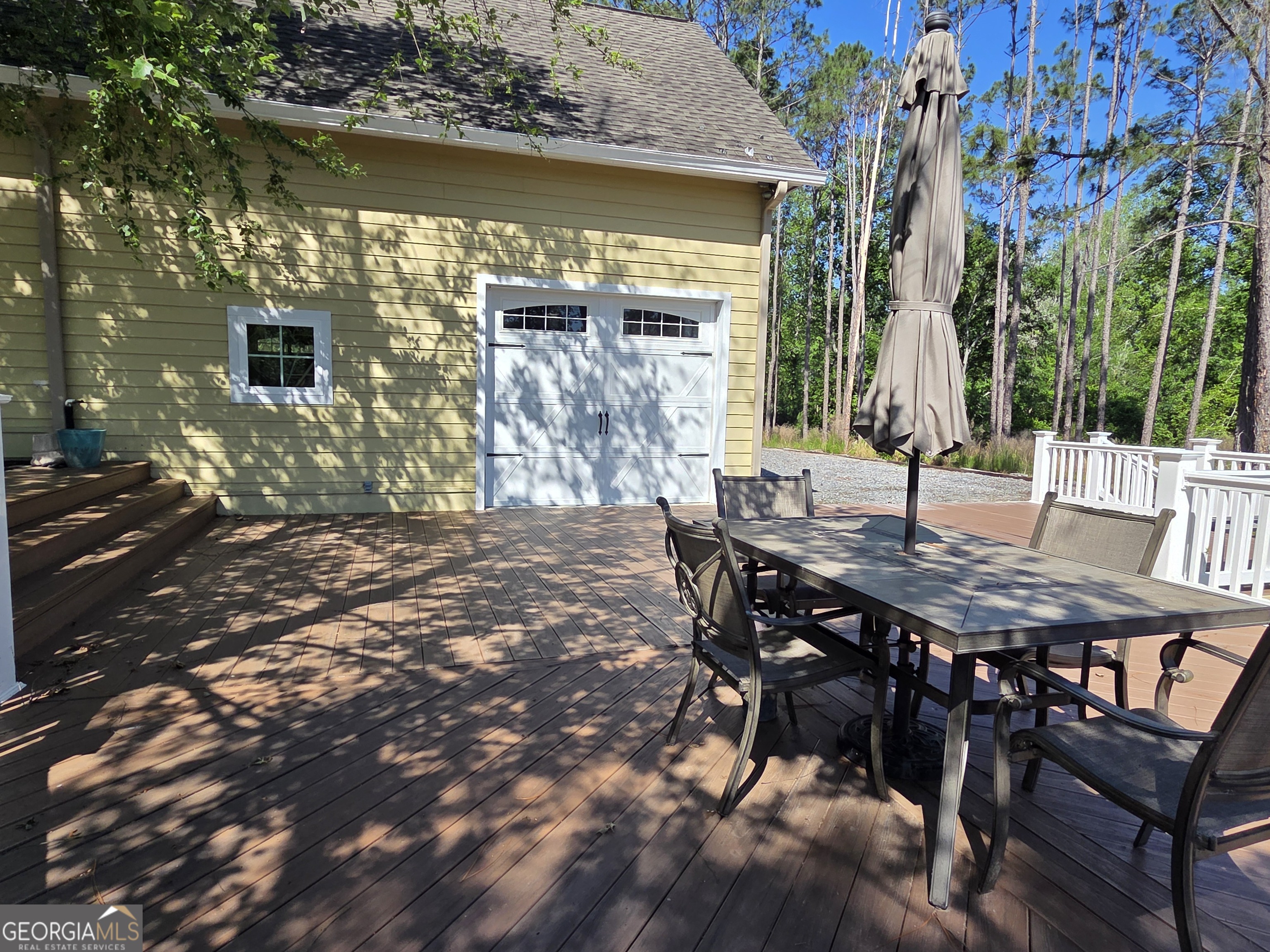 300 Hammond Powell Road Hazlehurst, GA 31539 - Photo 27 of 91 a view of a patio with table and chairs with wooden floor and fence