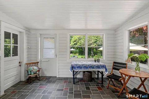 a view of a patio with table and chairs with a wooden floor and plants
