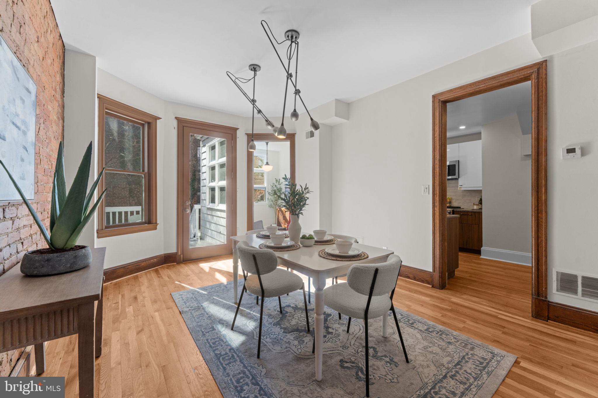 1802 Lamont Street Northwest Washington, DC 20010 - Photo 18 of 118 a dining room with furniture wooden floor a potted plant and a chandelier
