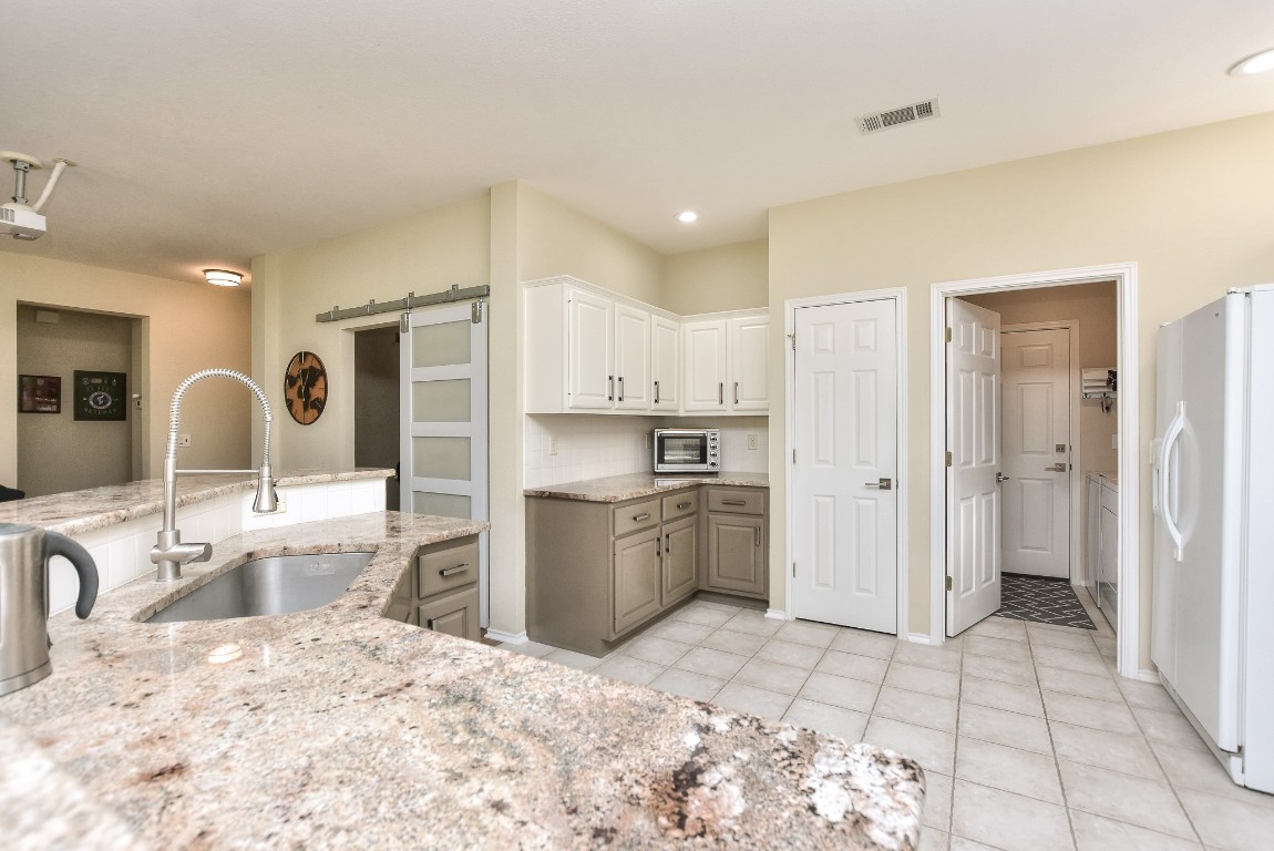 116 Dandelion Drive Georgetown, TX 78633 - Photo 13 of 31 Updated kitchen is a chef's delight, showcasing granite countertops, pull-out drawers for maximum storage, and newly painted cabinets (2025), complemented by a newer microwave (2024) and dishwasher (2023)