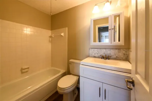 a bathroom with a sink toilet vanity and bathtub