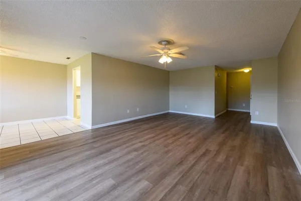 a view of an empty room with wooden floor