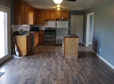 a kitchen with kitchen island granite countertop wooden floors and stainless steel appliances