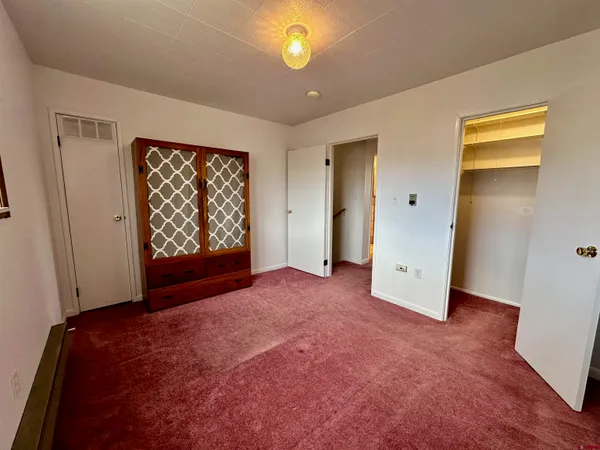 an empty room with windows and closet