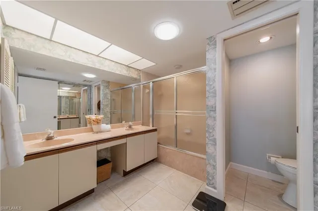 a bathroom with a double vanity sink toilet and shower