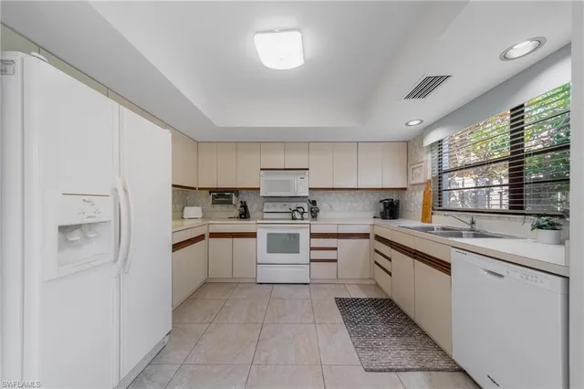 a kitchen with a sink window and cabinets