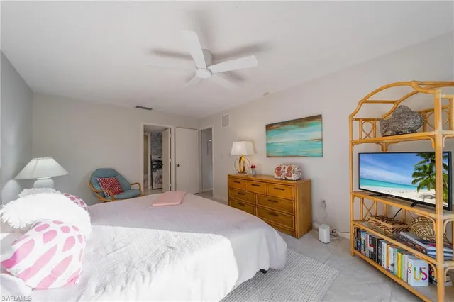 a bedroom with a bed and a flat tv screen on dresser