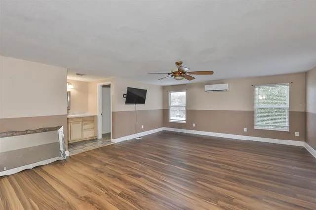 a view of empty room with wooden floor and window