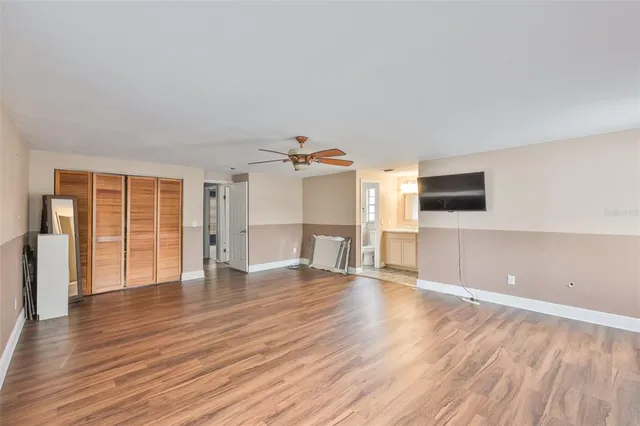 a view of a livingroom with wooden floor and a ceiling fan