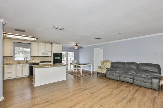 a living room with furniture and kitchen view
