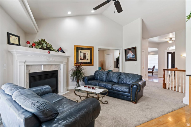 1924 North 2000th Street East Layton, UT 84040 - Photo 12 of 41 Living room featuring lofted ceiling, a ceiling fan, light carpet, light wood-style flooring, and a fireplace