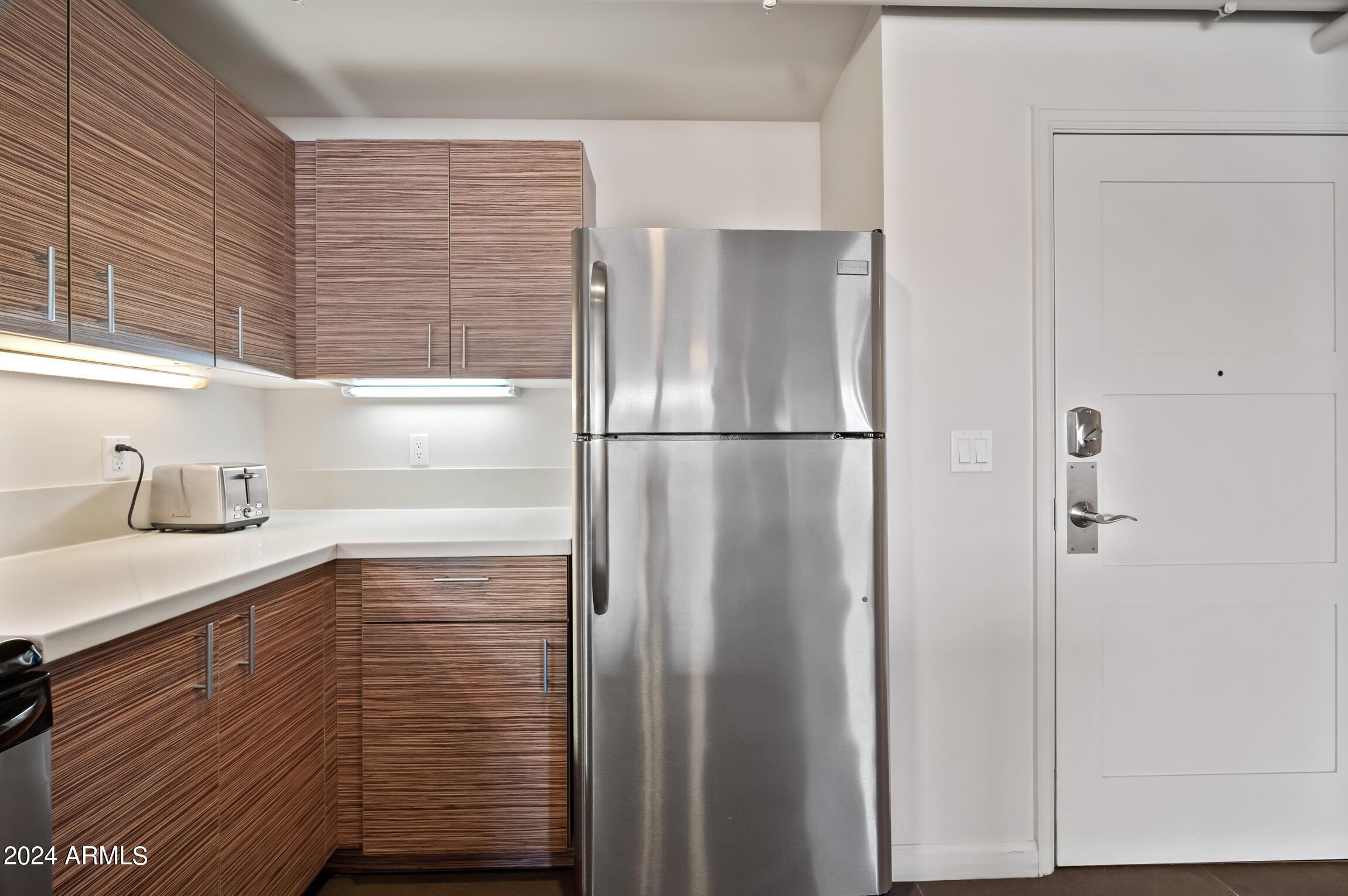 535 West Thomas Road, Unit 212 Phoenix, AZ 85013 - Photo 4 of 6 a kitchen with a refrigerator and cabinets