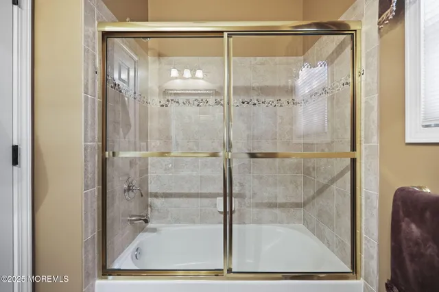 a spacious bedroom with a bed a chandelier and large window