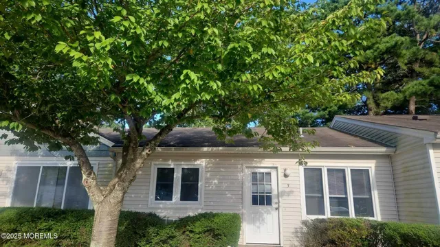 a front view of a house with a tree