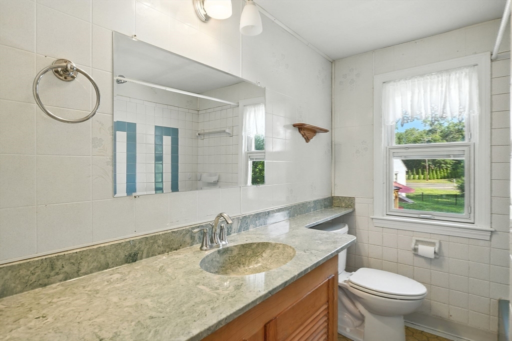 77 Bowers Street West Springfield, MA 01089 - Photo 25 of 36 a bathroom with a granite countertop toilet a sink and a mirror