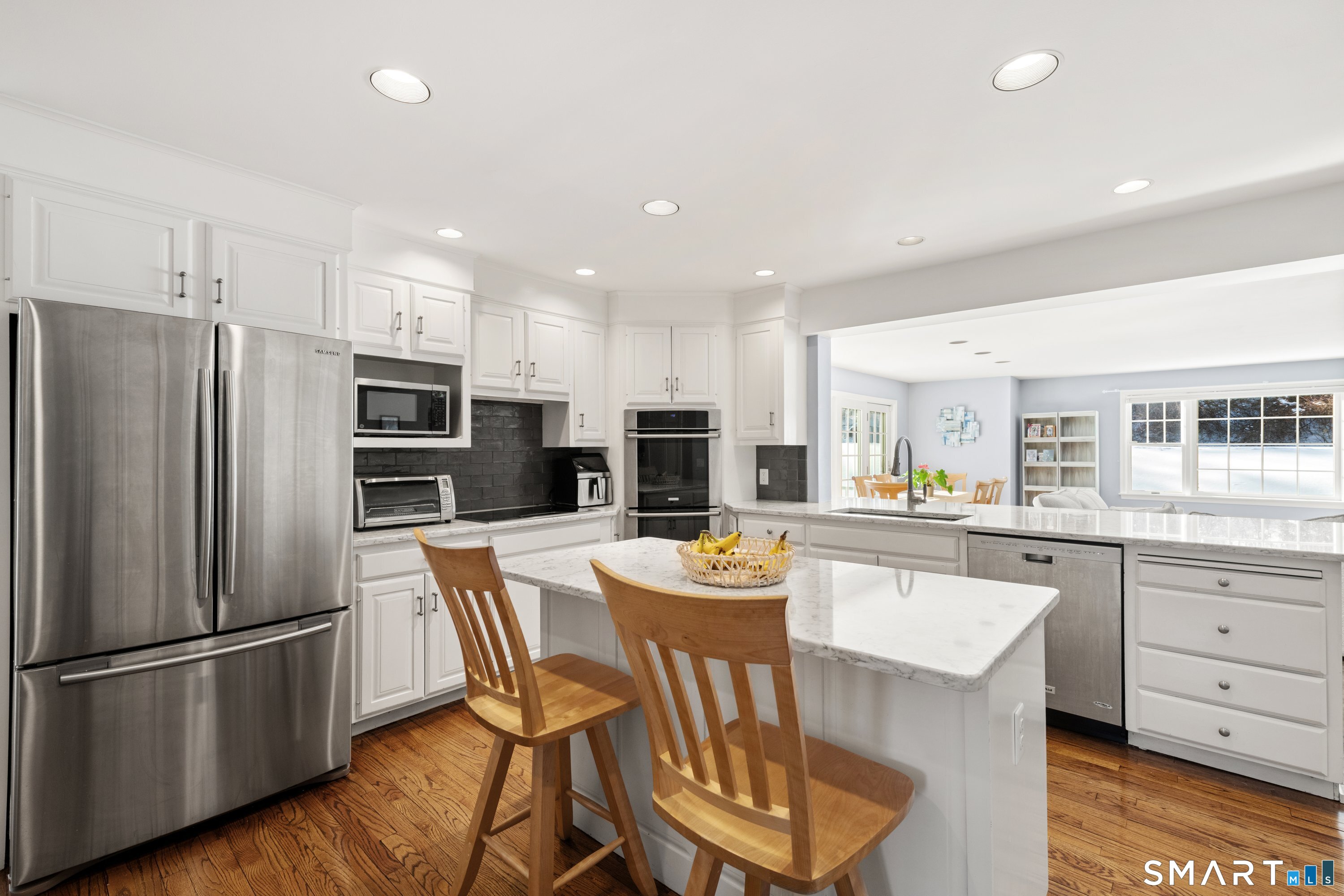 309 Sturges Ridge Road Wilton, CT 06897 - Photo 6 of 33 a kitchen with stainless steel appliances a refrigerator a stove a sink a dining table and chairs