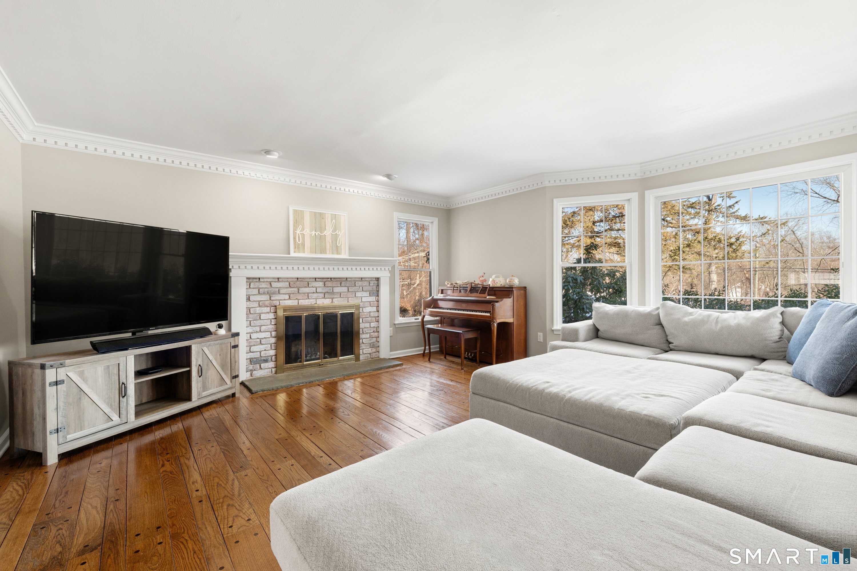 309 Sturges Ridge Road Wilton, CT 06897 - Photo 9 of 33 a living room with furniture a flat screen tv and a fireplace