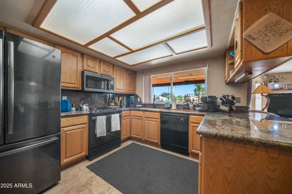 a kitchen with stainless steel appliances granite countertop a sink and a stove