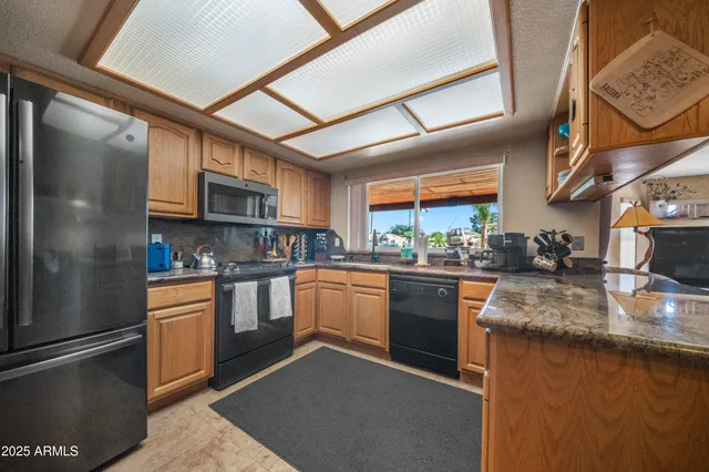 a kitchen with stainless steel appliances granite countertop a sink and a stove