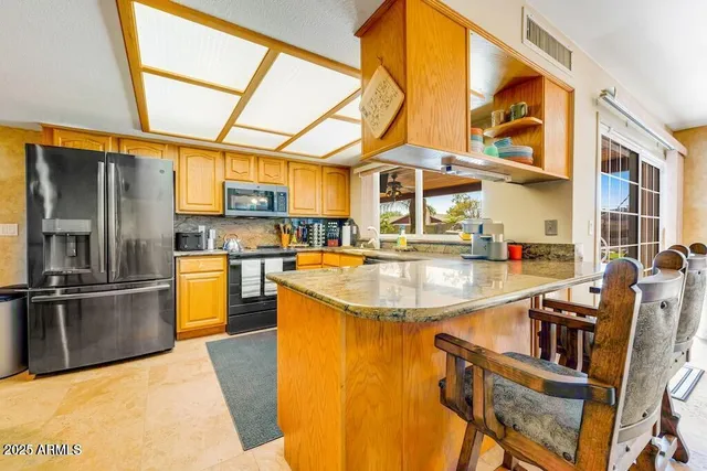 a living room with furniture kitchen view and a chandelier