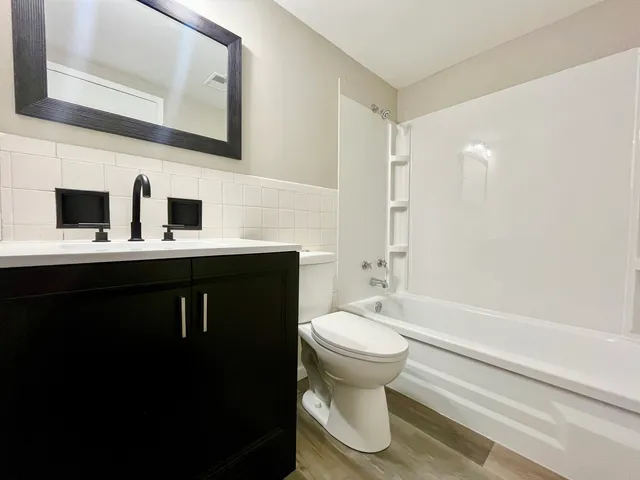 a bathroom with a sink a toilet and shower