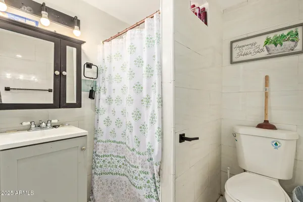 a bathroom with a sink a toilet and shower curtain