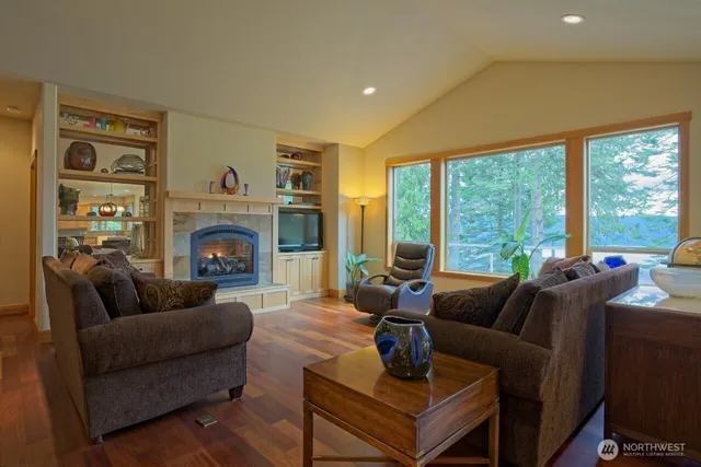 a living room with furniture a large window and a fireplace