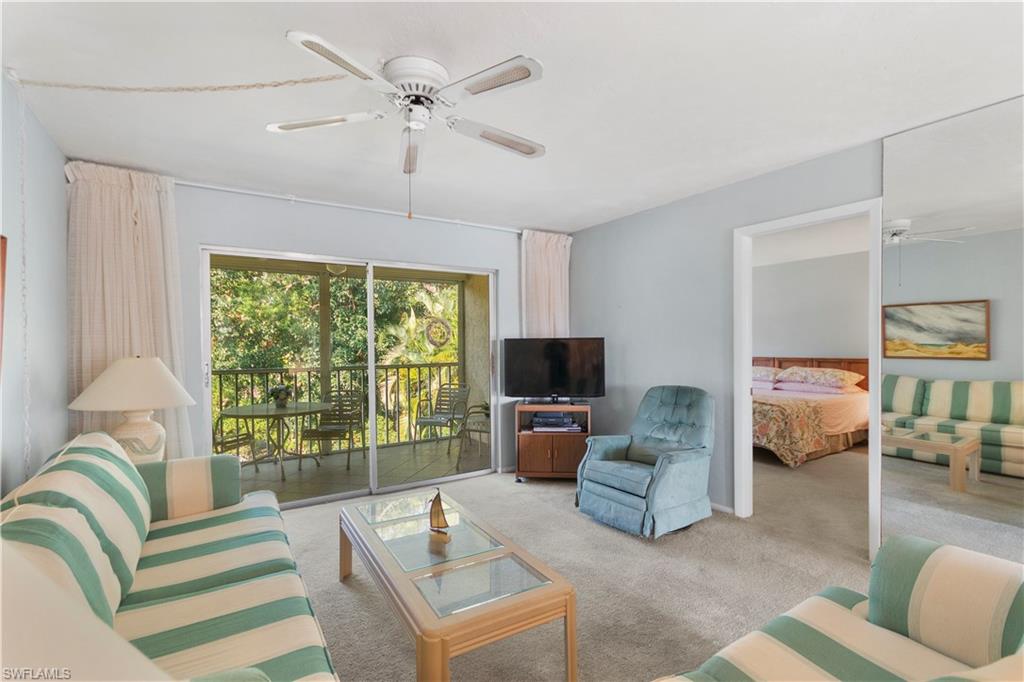 499 Forest Lakes Boulevard, Unit 2304 Naples, FL 34105 - Photo 12 of 21 a living room with furniture and a flat screen tv
