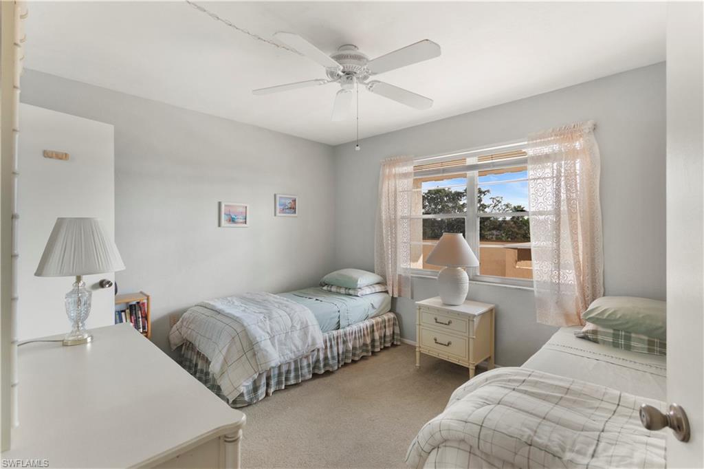 499 Forest Lakes Boulevard, Unit 2304 Naples, FL 34105 - Photo 18 of 21 a bedroom with two beds and a large window
