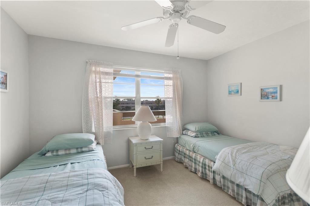 499 Forest Lakes Boulevard, Unit 2304 Naples, FL 34105 - Photo 19 of 21 a bedroom with a bed and a chandelier