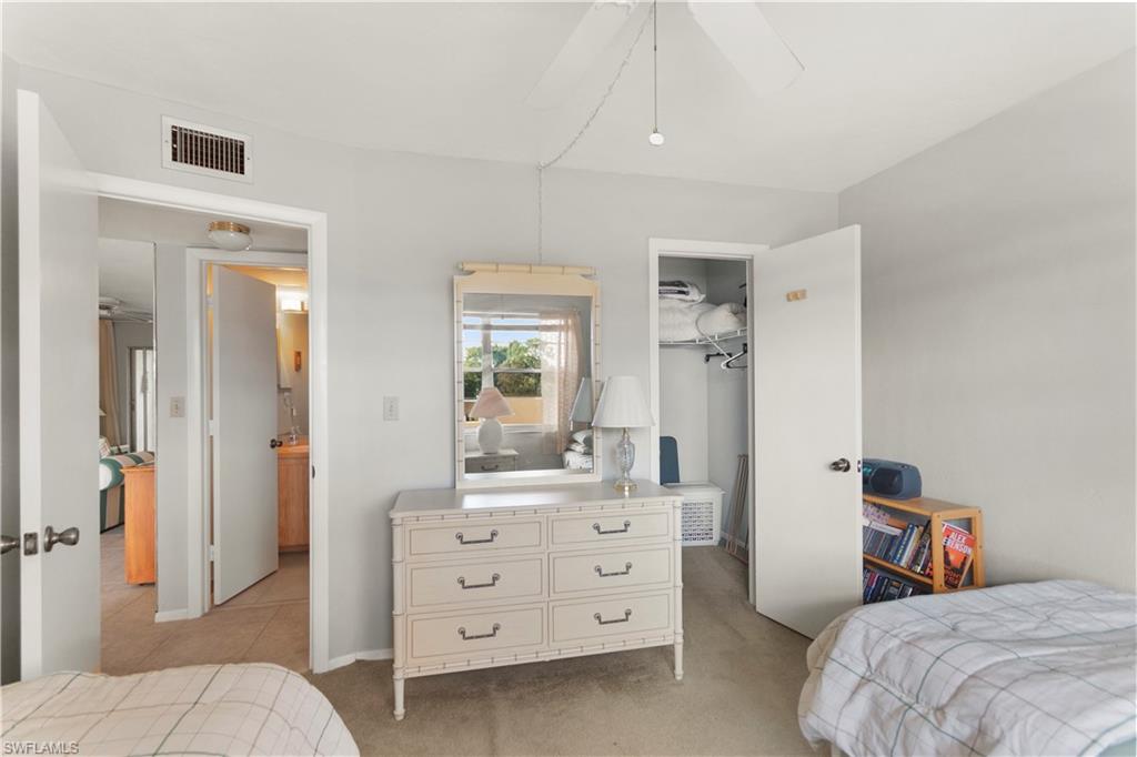 499 Forest Lakes Boulevard, Unit 2304 Naples, FL 34105 - Photo 20 of 21 a bedroom with a bed and a dresser