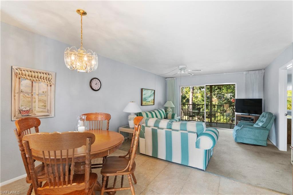 499 Forest Lakes Boulevard, Unit 2304 Naples, FL 34105 - Photo 2 of 21 a dining room with furniture a livingroom and chandelier