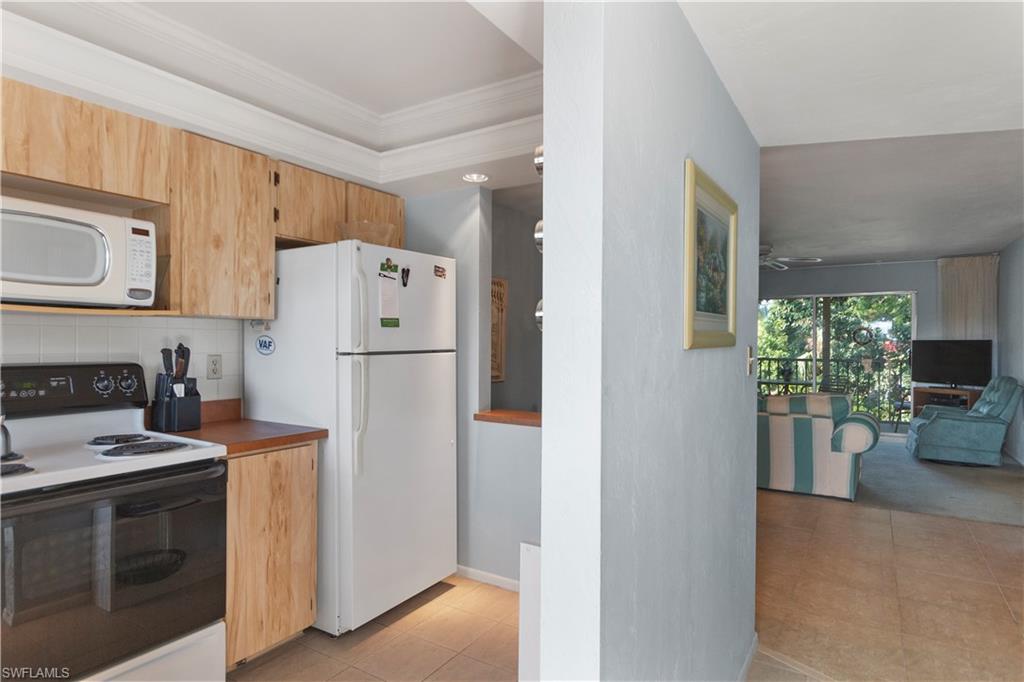 499 Forest Lakes Boulevard, Unit 2304 Naples, FL 34105 - Photo 7 of 21 a kitchen with a refrigerator stove and sink
