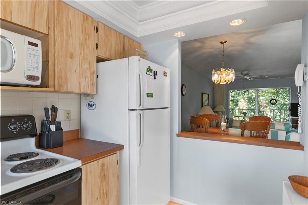 499 Forest Lakes Boulevard, Unit 2304 Naples, FL 34105 - Photo 8 of 21 a kitchen with stainless steel appliances a refrigerator a sink a stove and a window